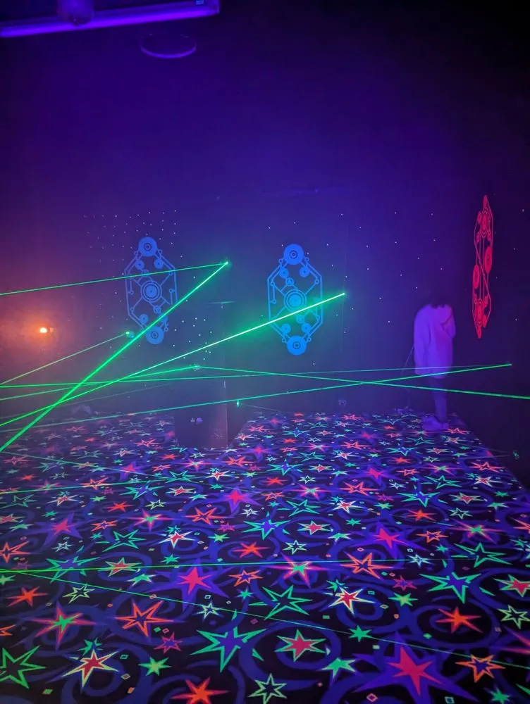 Person crawling under laser grid beams in the maze