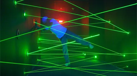 Green laser grid beams in a dark room inside the laser maze