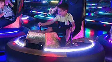 Boy excited about playing with glowing bumper car